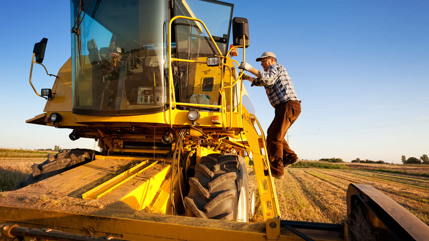 farmer climbing onto tractor